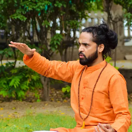 Tarachand ji in a cross-legged seat, one arm extended as he demonstrates a movement